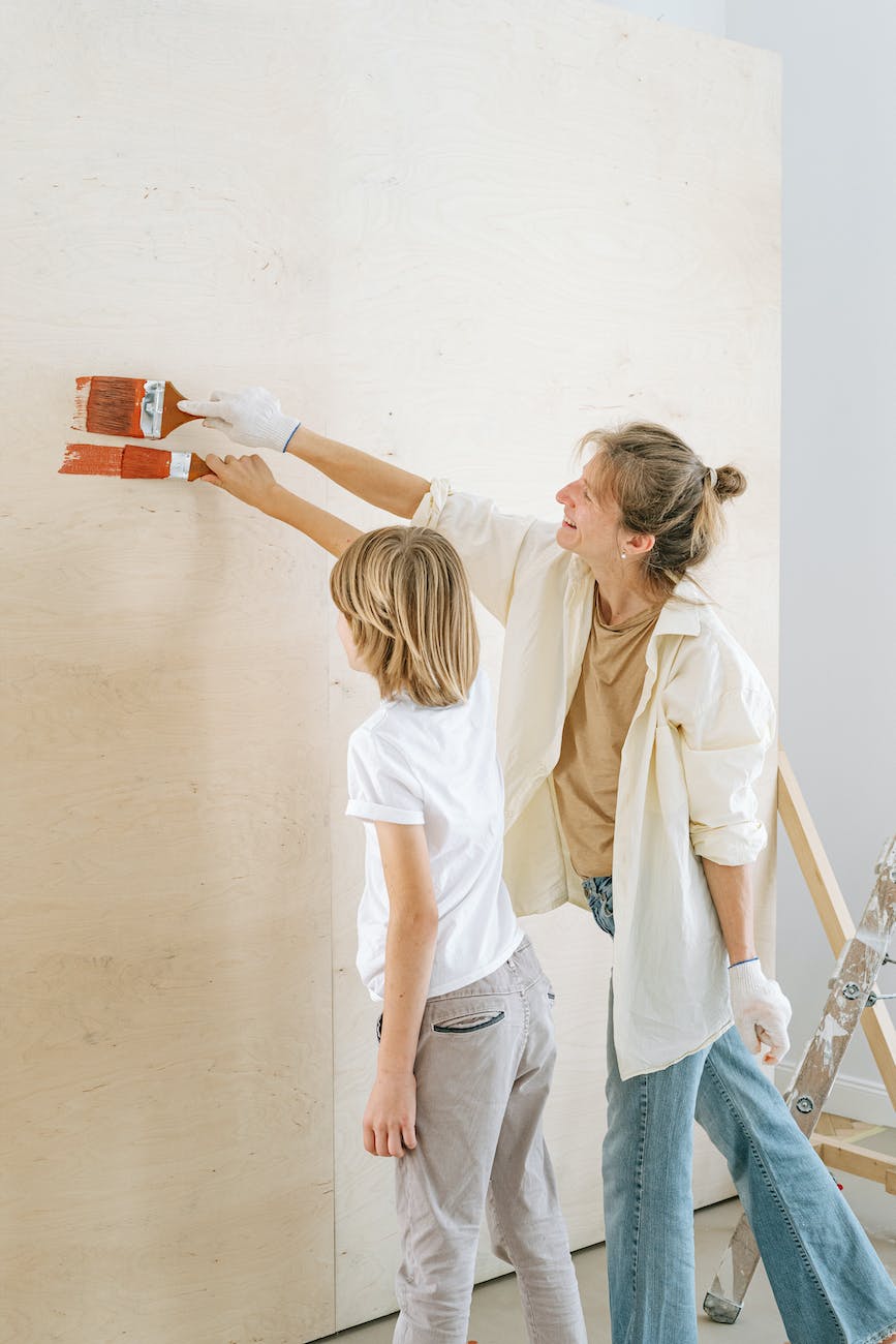 a mother and son painting a wall